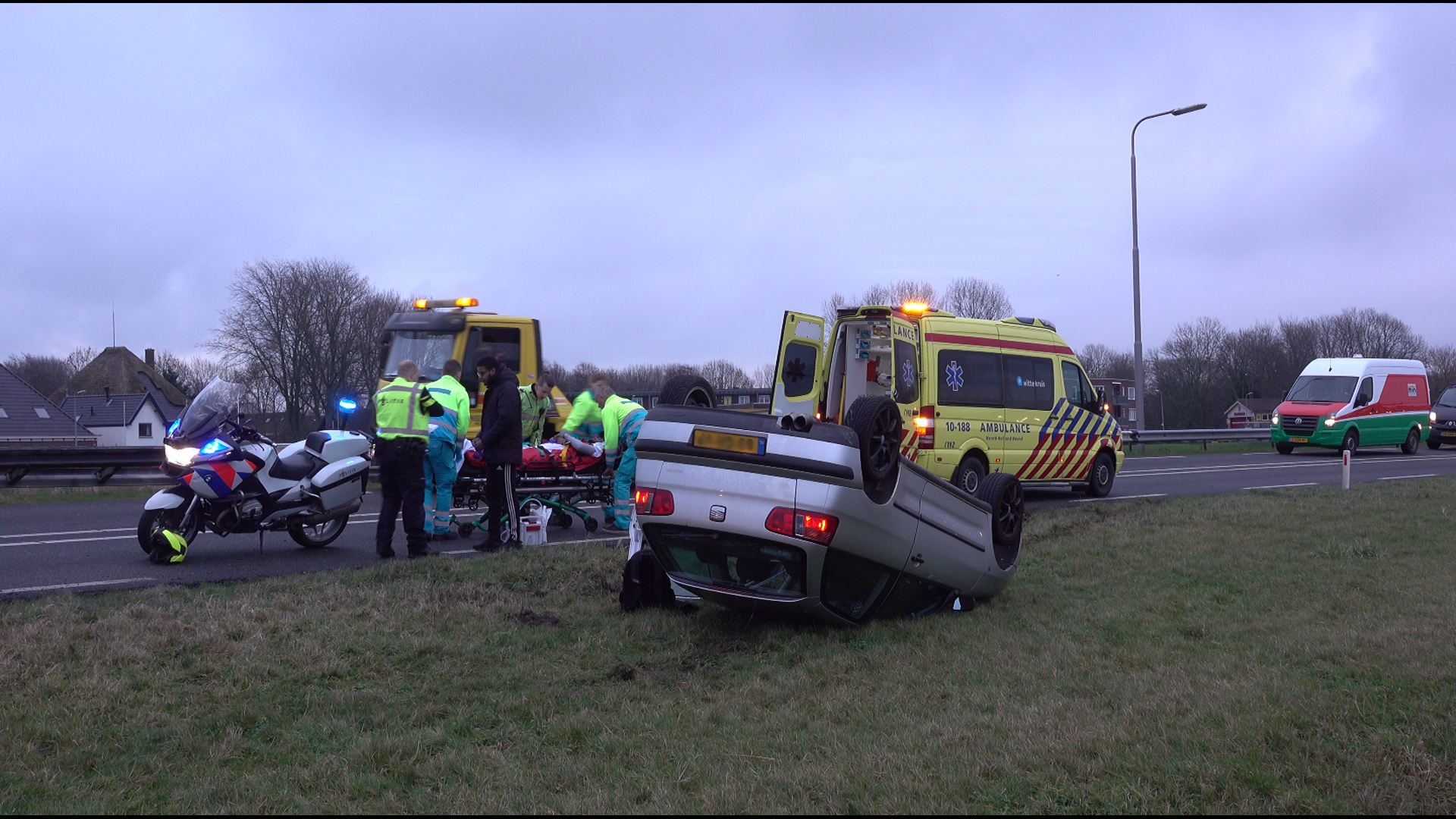 Auto op de kop naast N9, bestuurder gewond (VIDEO)