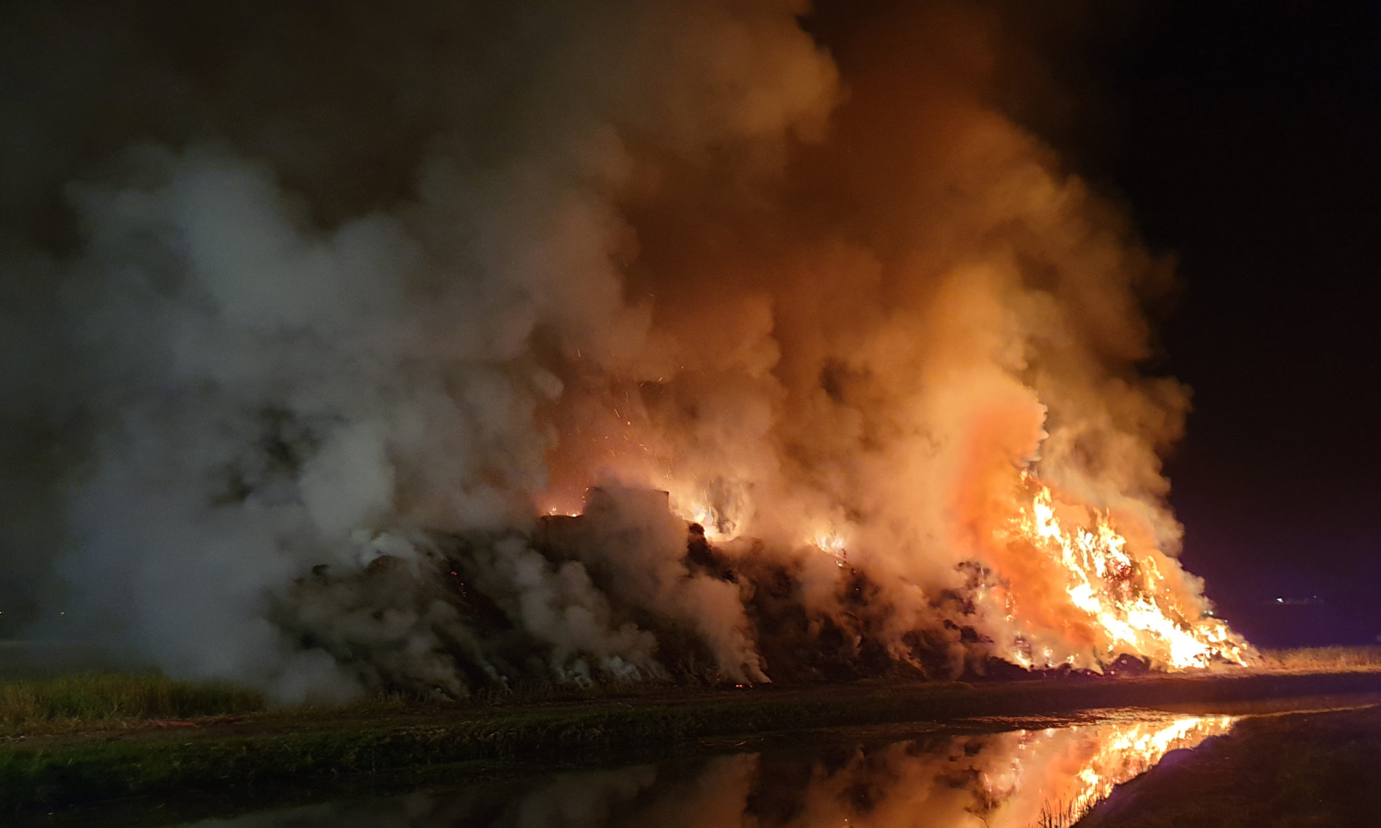 Vlammen van hooibrand Kanaalweg van veraf te zien