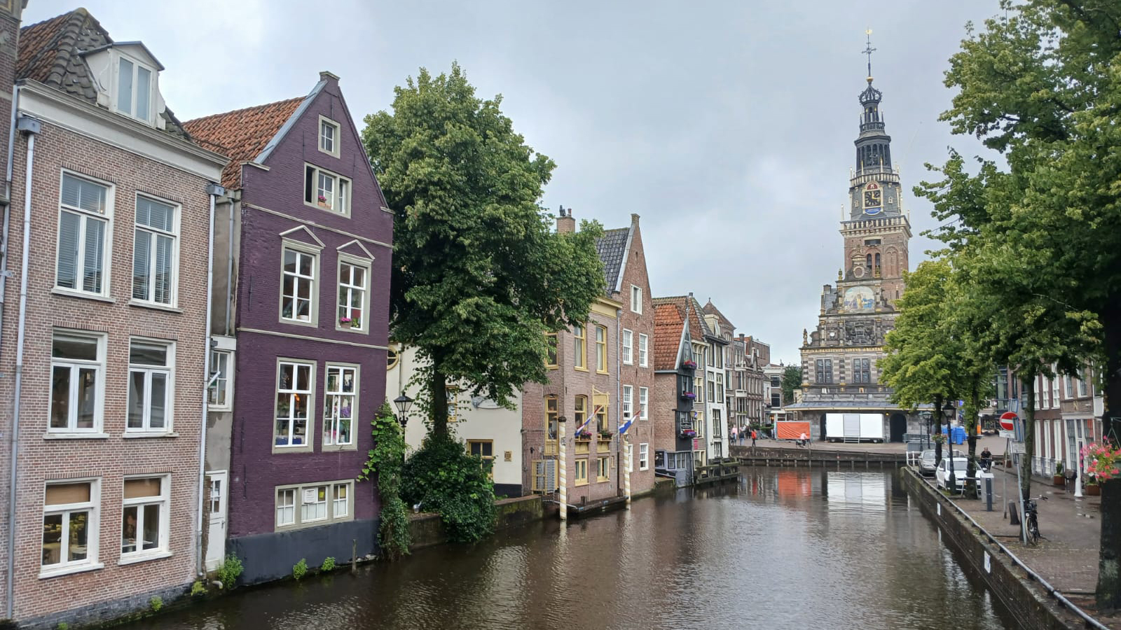 Kanaal met traditionele Nederlandse huizen en kerk op de achtergrond in een historische stad.