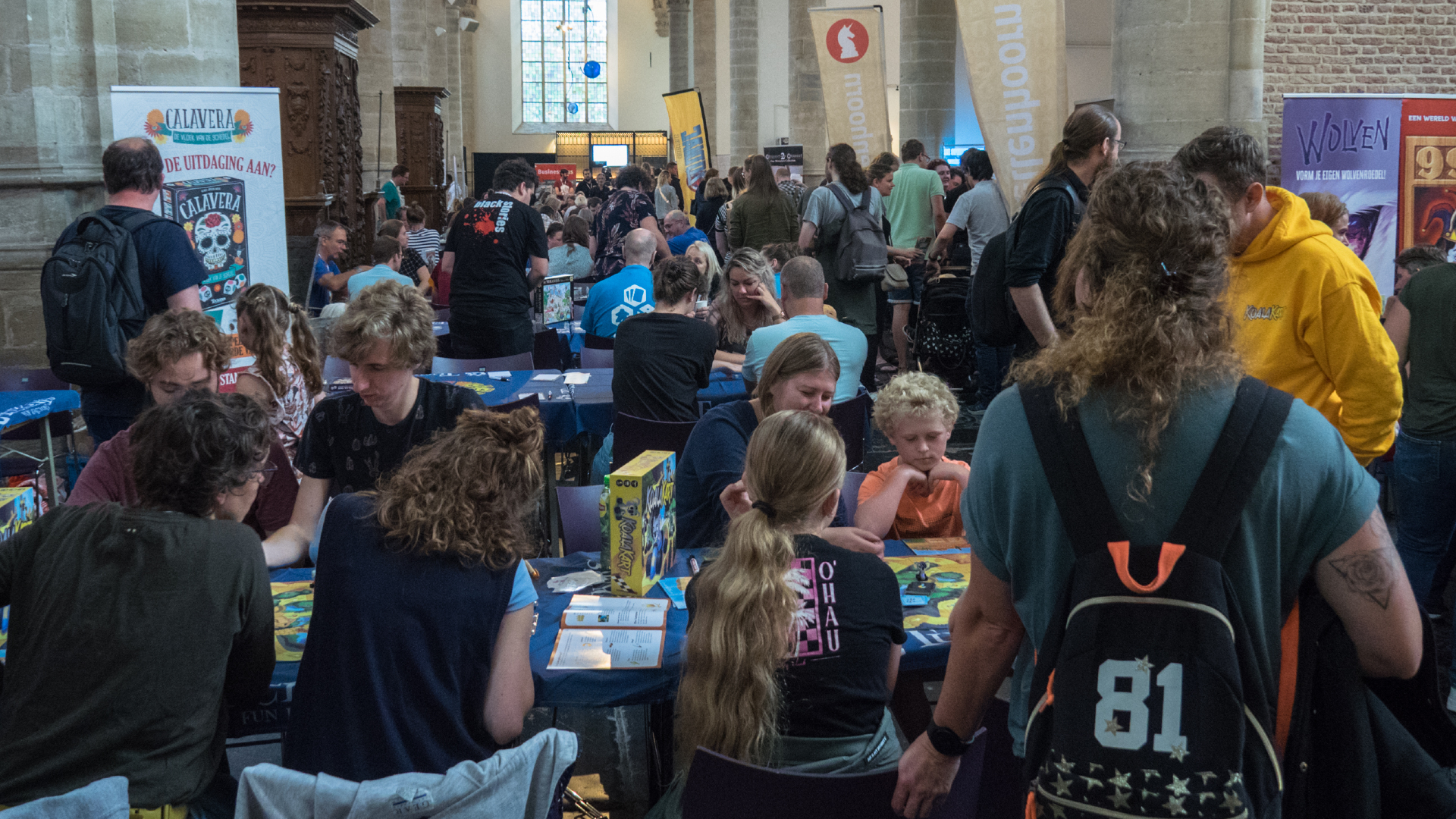 Mensen spelen bordspellen op een druk evenement in een kerk.