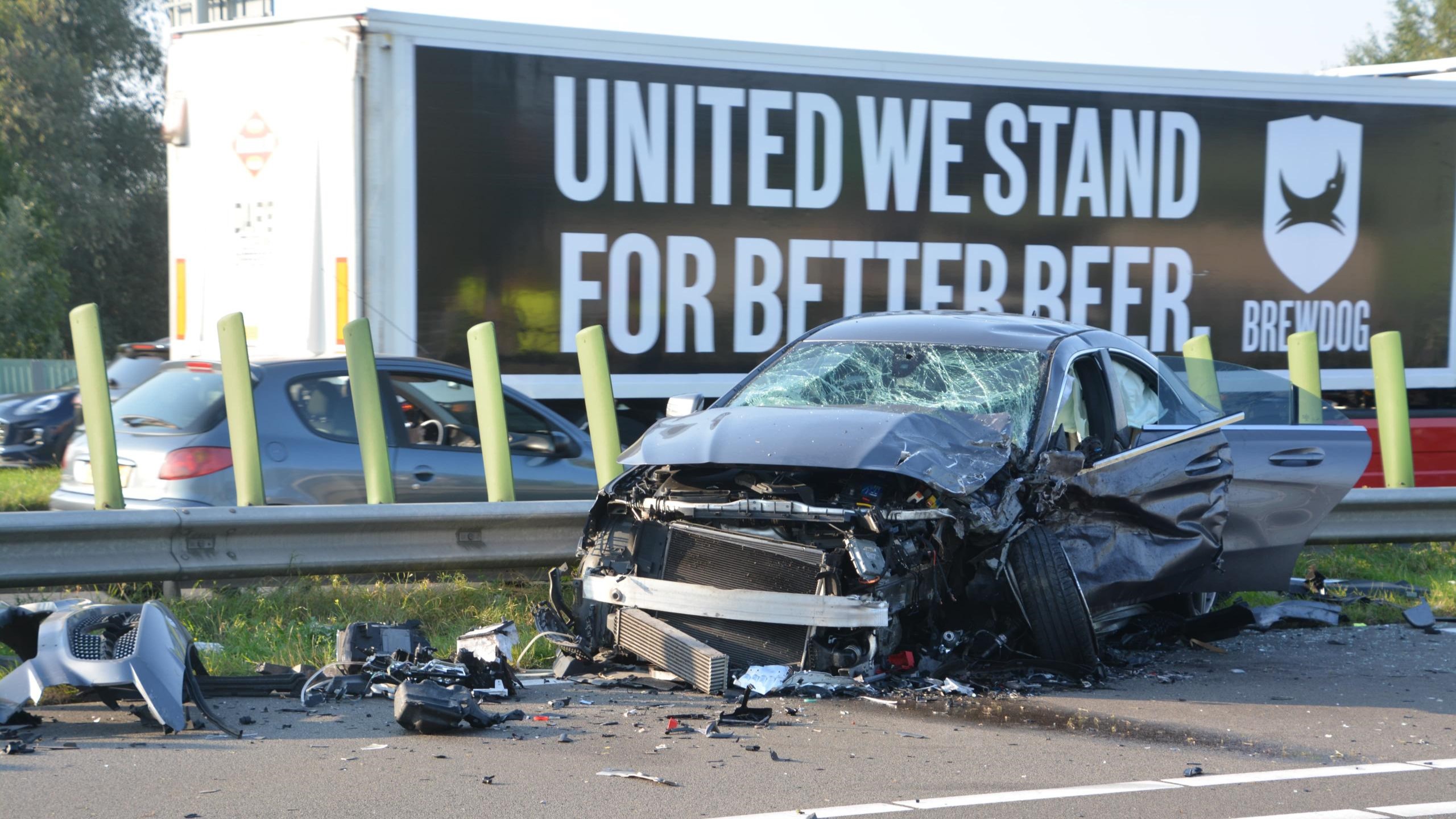 Auto-ongeluk op de snelweg voor een vrachtwagen met een reclamebord.