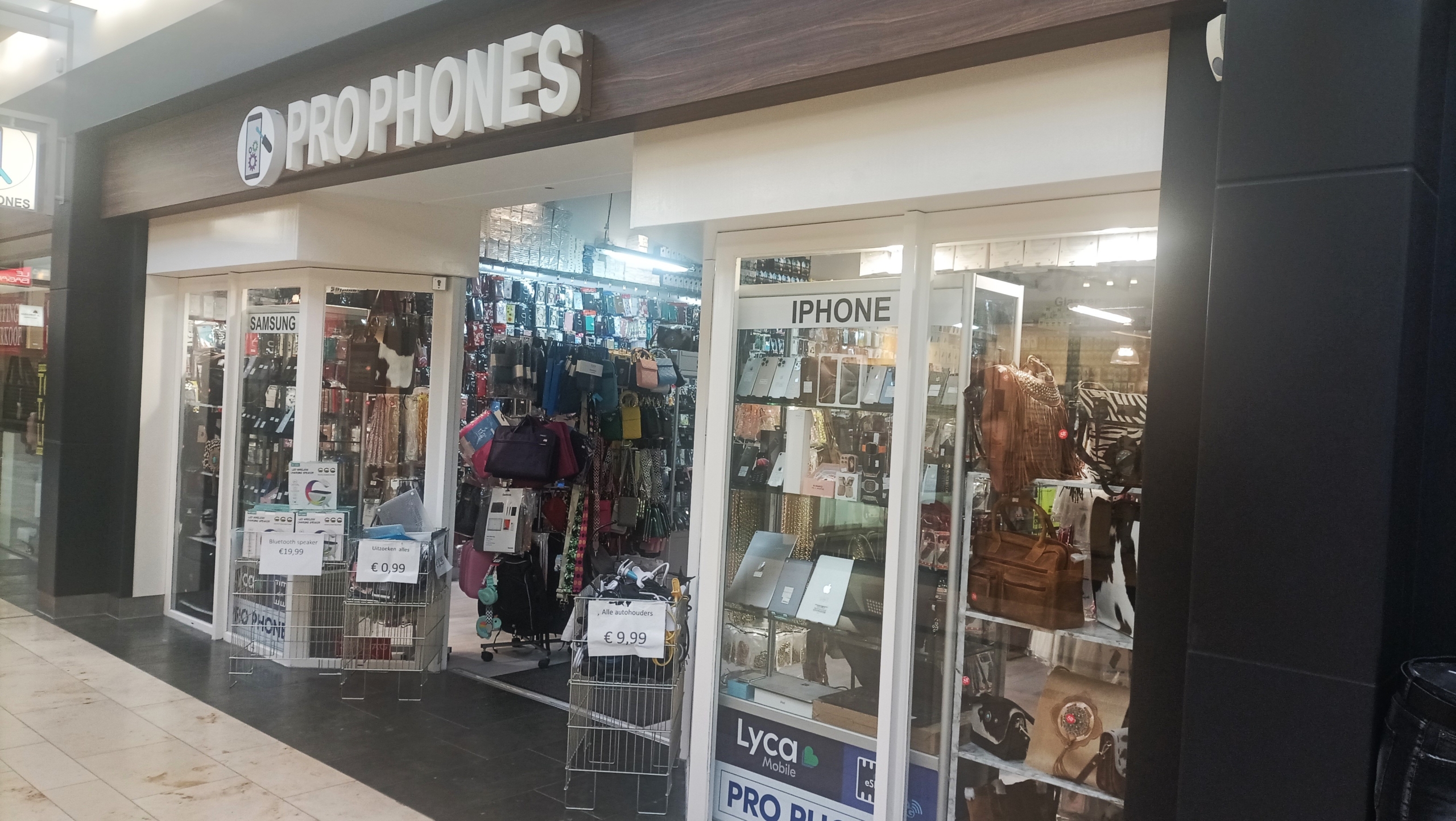 Winkel genaamd "Pro Phones" die telefoonaccessoires en tassen verkoopt in een winkelcentrum.