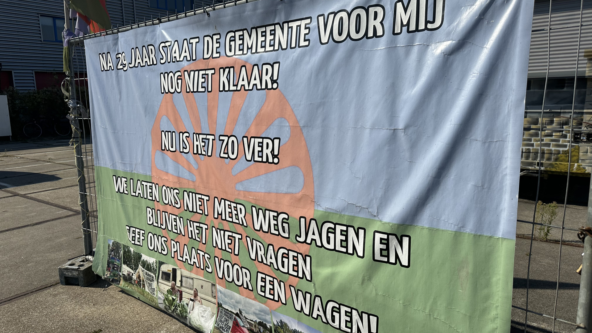 Spandoek met tekst: "Na 29 jaar staat de gemeente voor mij nog niet klaar! Nu is het zo ver! We laten ons niet meer weg jagen en blijven het niet vragen. Geef ons plaats voor een wagen!"