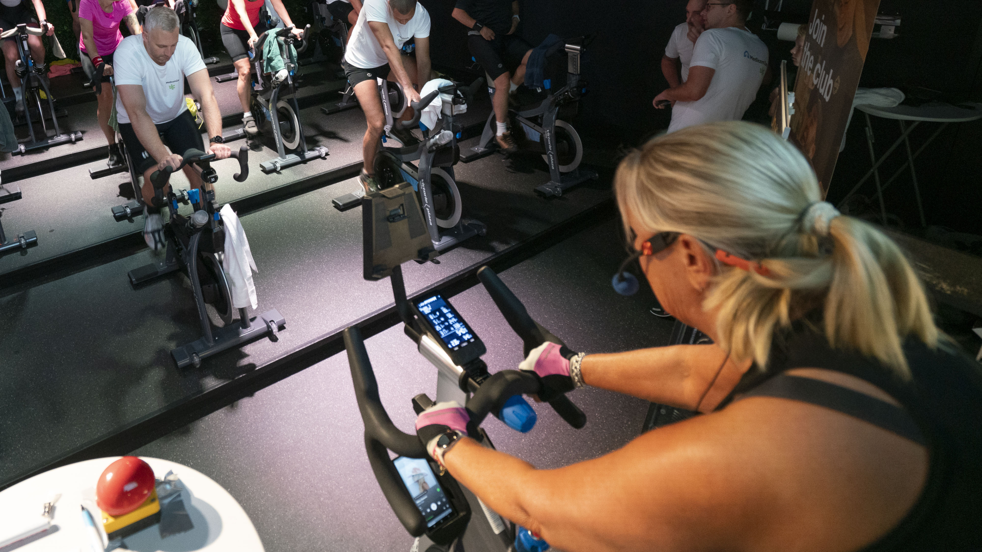 Een groep mensen doet aan indoor spinning in een sportschool.