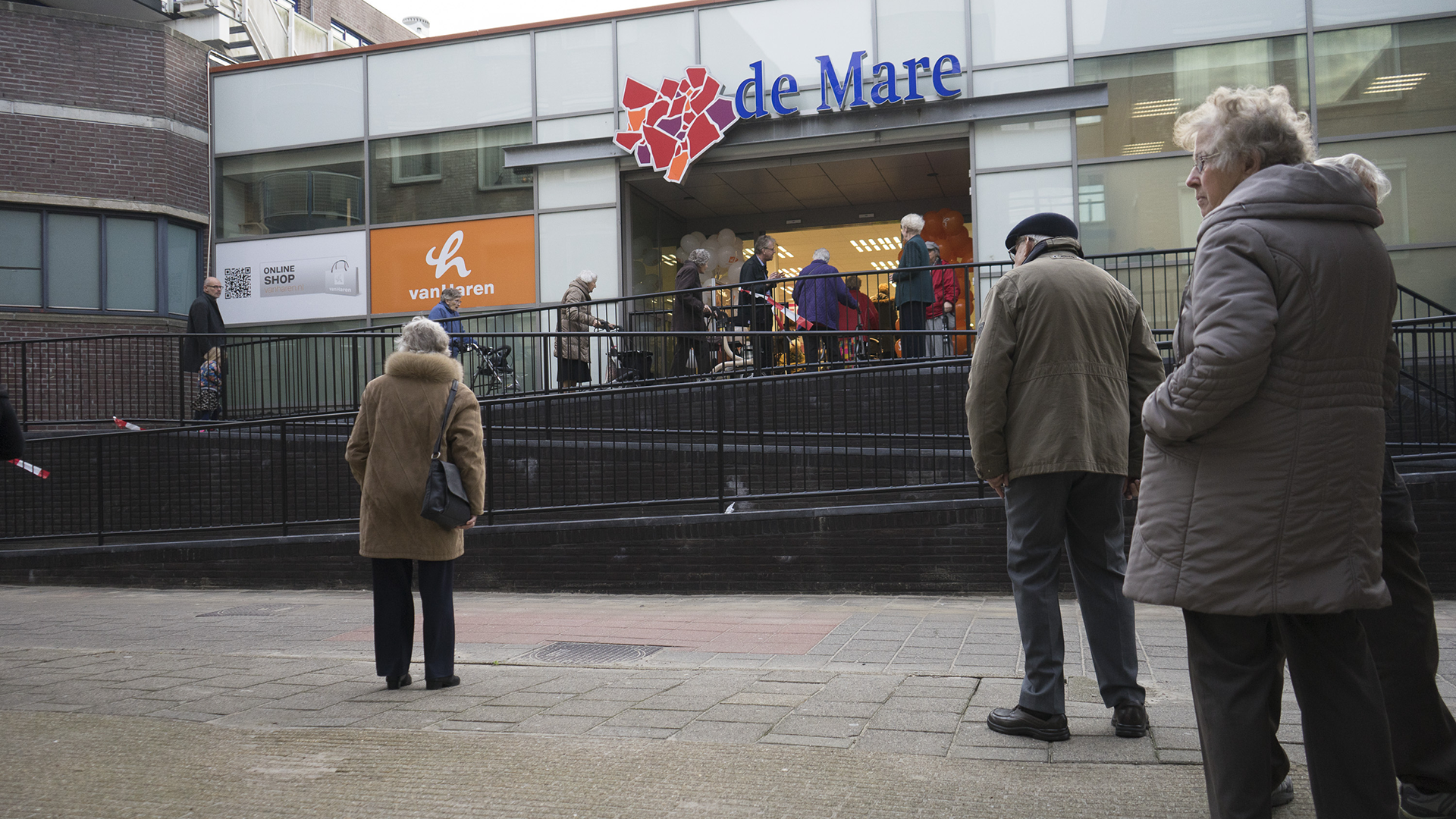 Mensen buiten winkelcentrum de Mare in een stadsomgeving.