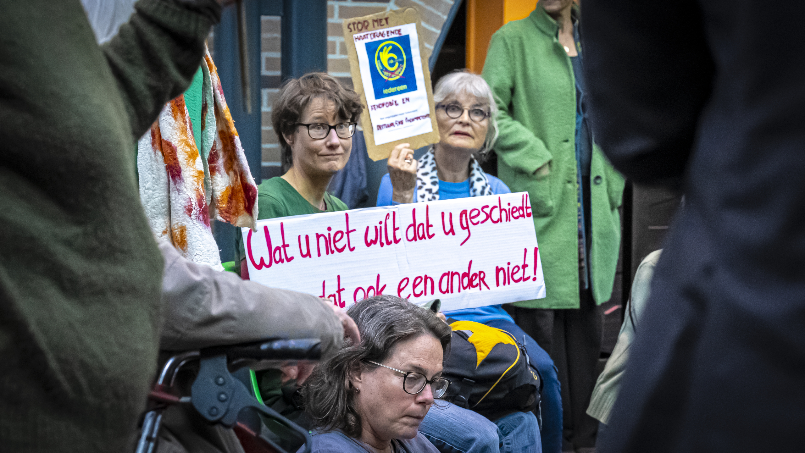 Mensen houden protestborden vast met teksten tijdens een demonstratie.