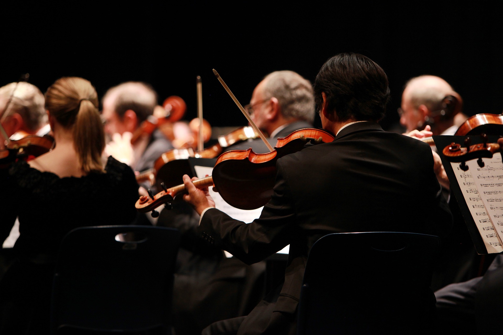 Muzikanten in een orkest spelen viool tijdens een uitvoering.