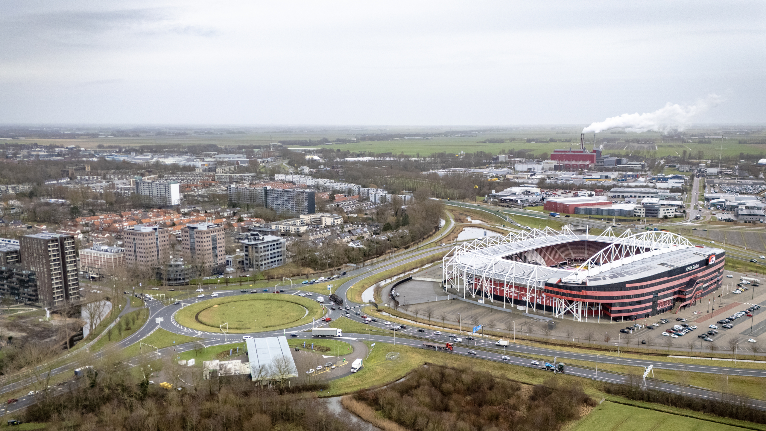 Luchtfoto van een stadion en omliggende bebouwing in een stad.
