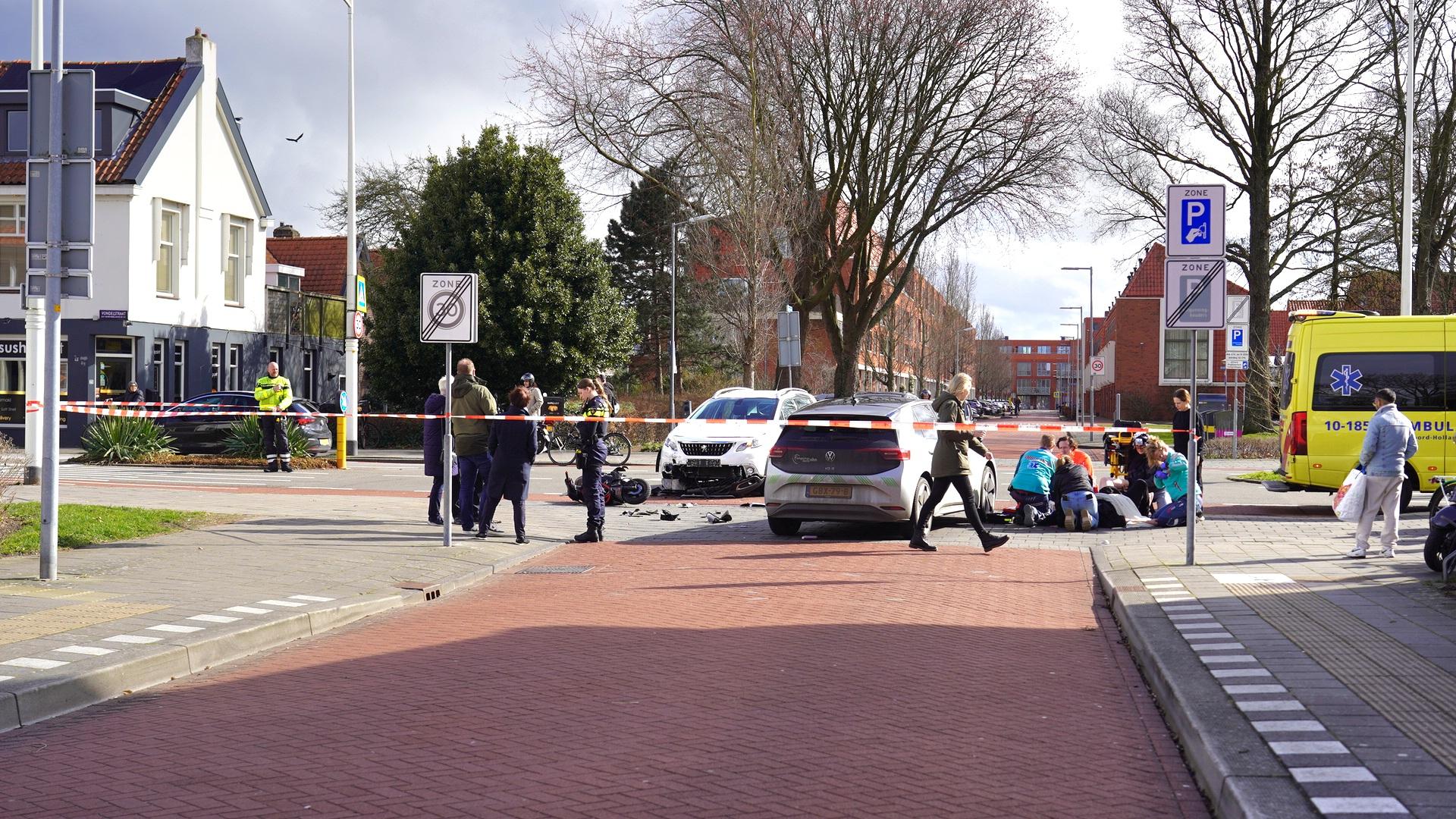 Verkeersongeluk met meerdere voertuigen, politie en medisch personeel aanwezig, afzetlint en ambulance ter plaatse.