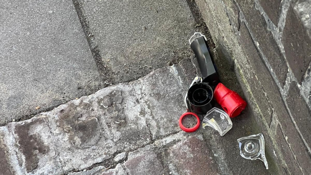 Verlaten fietsslot in gebroken staat ligt op een stoep naast een muur.