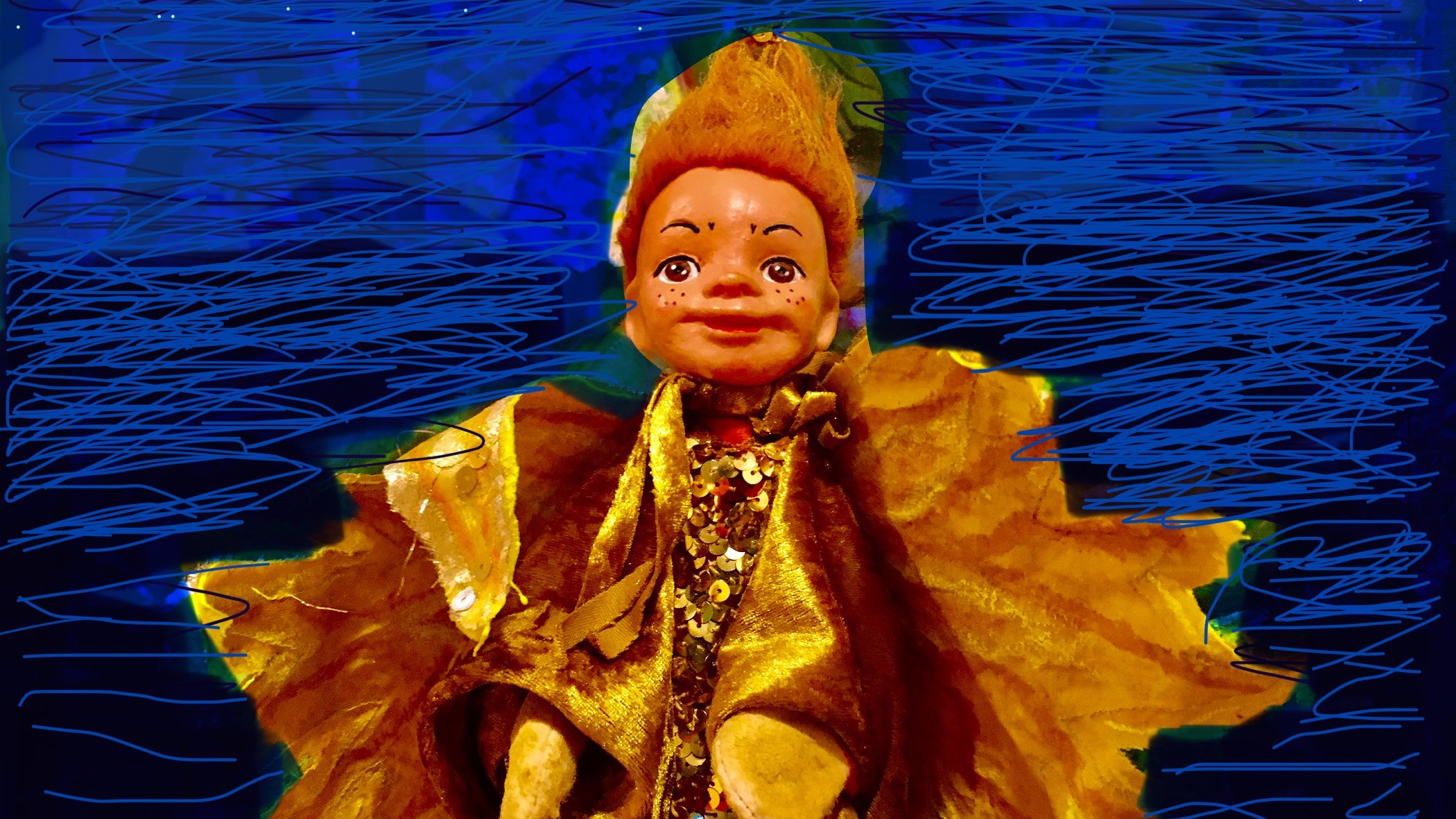 Een pop met een glimlachend gezicht, oranje haar, en sproeten in een kleurrijk gouden glinsterende kostuum, tegen een blauwe achtergrond.