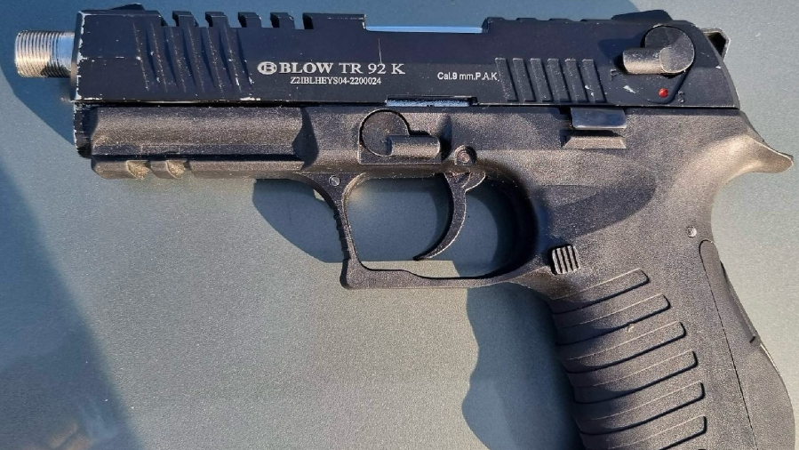 Een zwart pistool van het merk Blow TR 92 K met kaliber 9 mm P.A.K., liggend op een oppervlak.