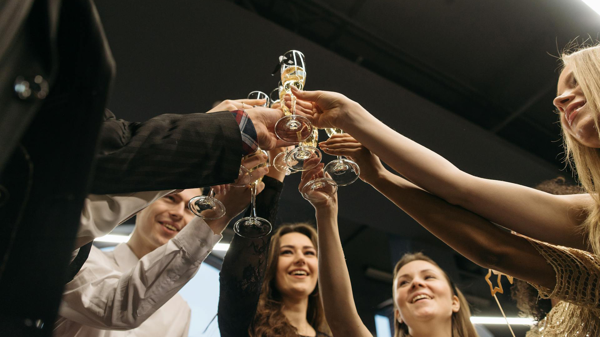 Een groep mensen heft glazen champagne terwijl ze samen toosten tijdens een viering.