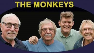 Vier oudere mannen poseren samen voor een foto met de tekst "THE MONKEYS" boven hen.
