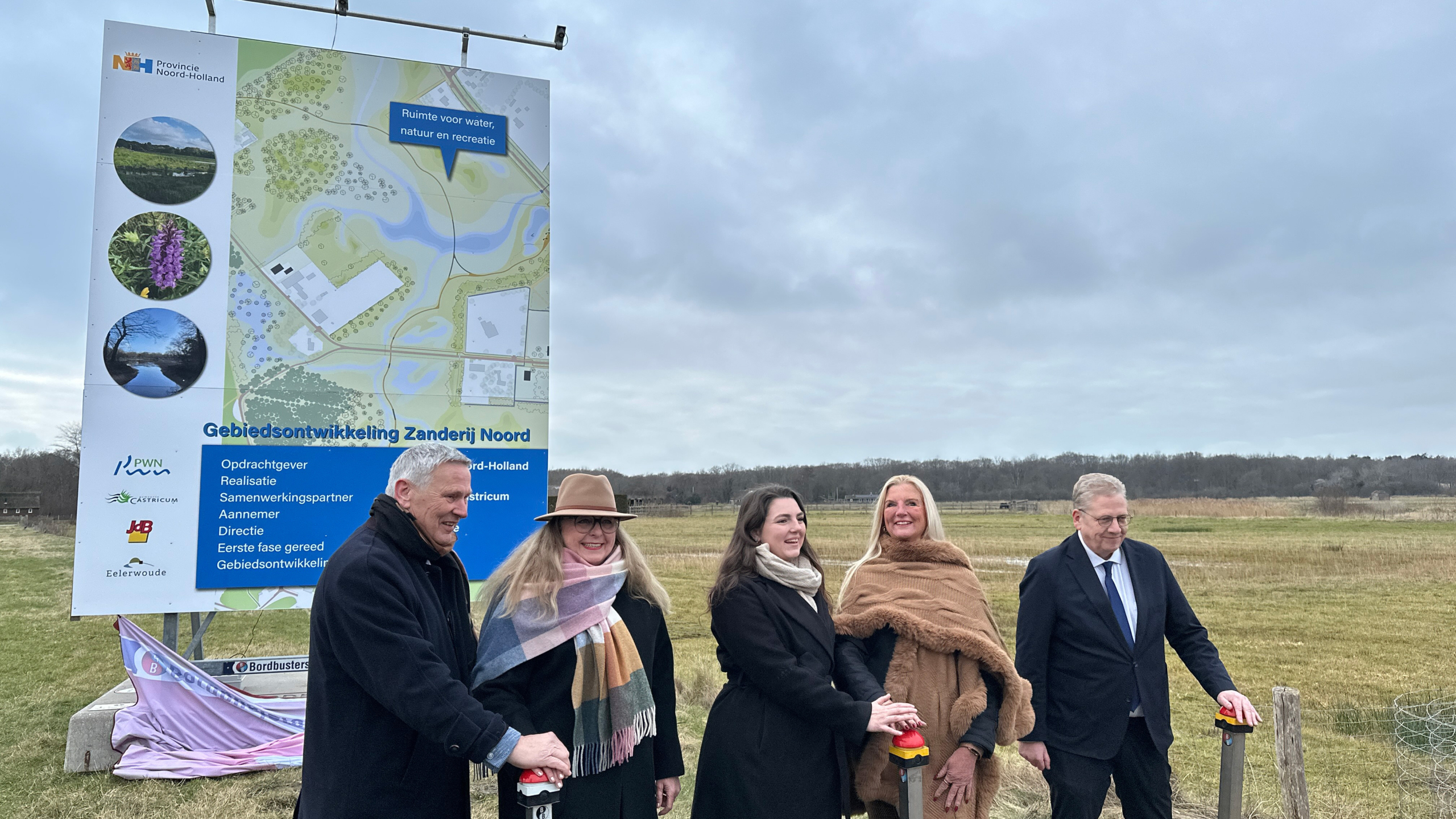 Vijf mensen staan buiten voor een bord met een kaart van gebiedsontwikkeling Zanderij Noord in Noord-Holland.