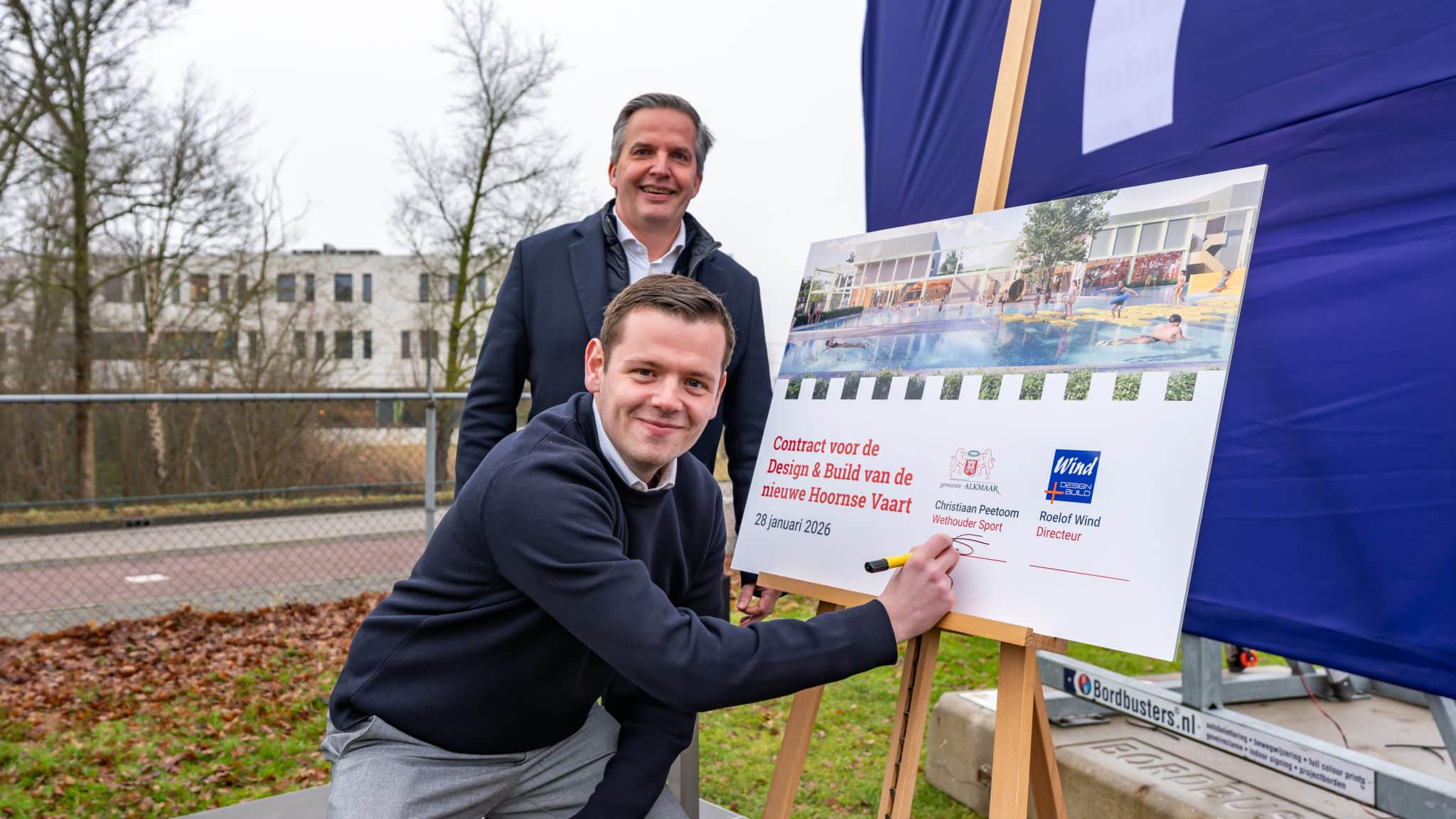 Twee mannen poseren bij een bord met contractinformatie voor de nieuwe Hoornse Vaart, dat op 28 januari 2026 is gedateerd.