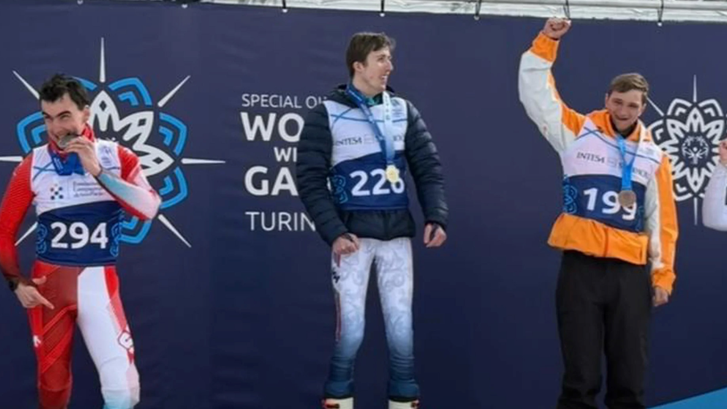 Drie medaillewinnaars poseren op een podium bij de Special Olympics World Winter Games in Turijn.