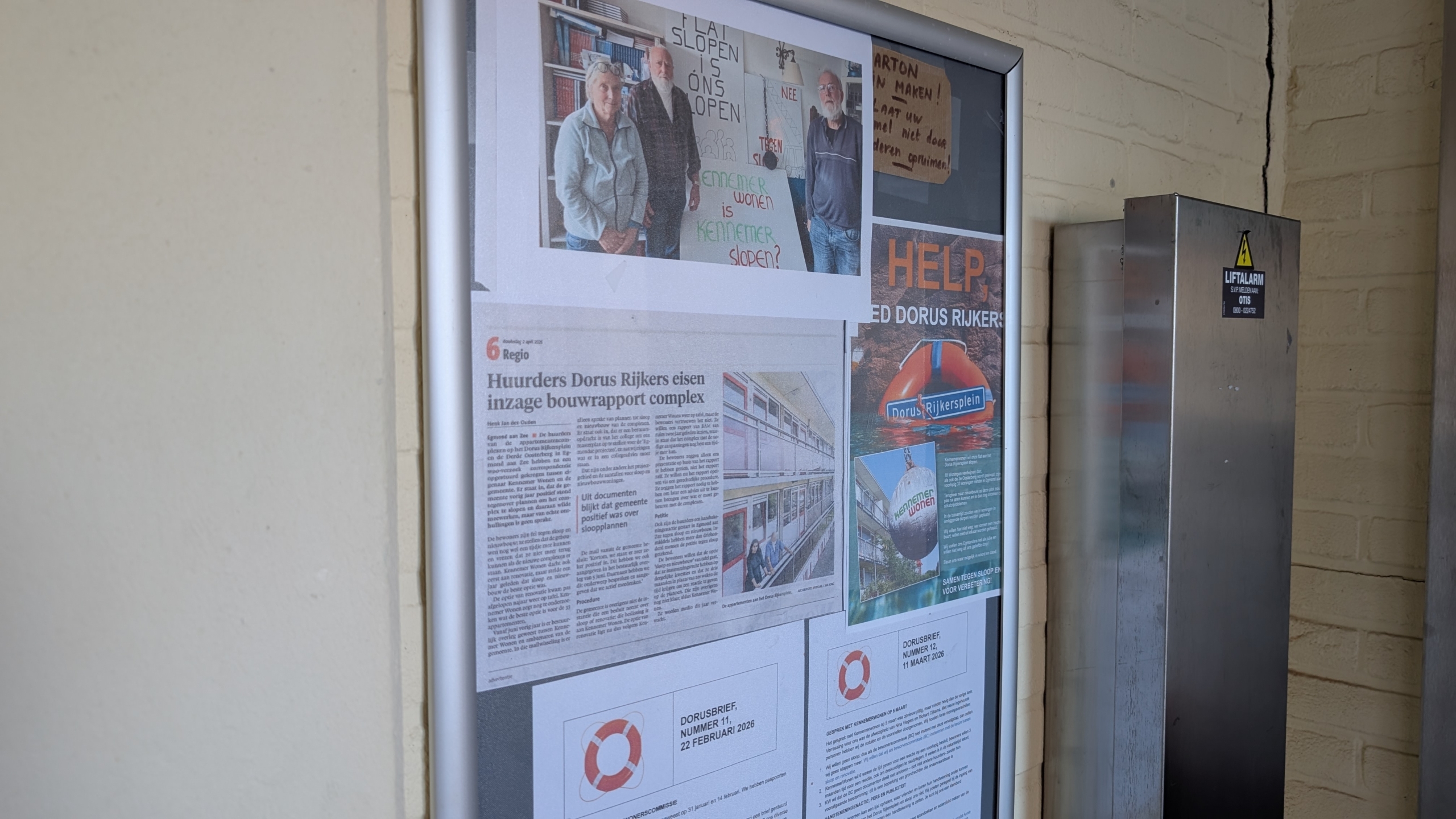 Informatiebord met krantenartikelen en posters over huurders die protesteren tegen sloopplannen van Dorus Rijkersplein.