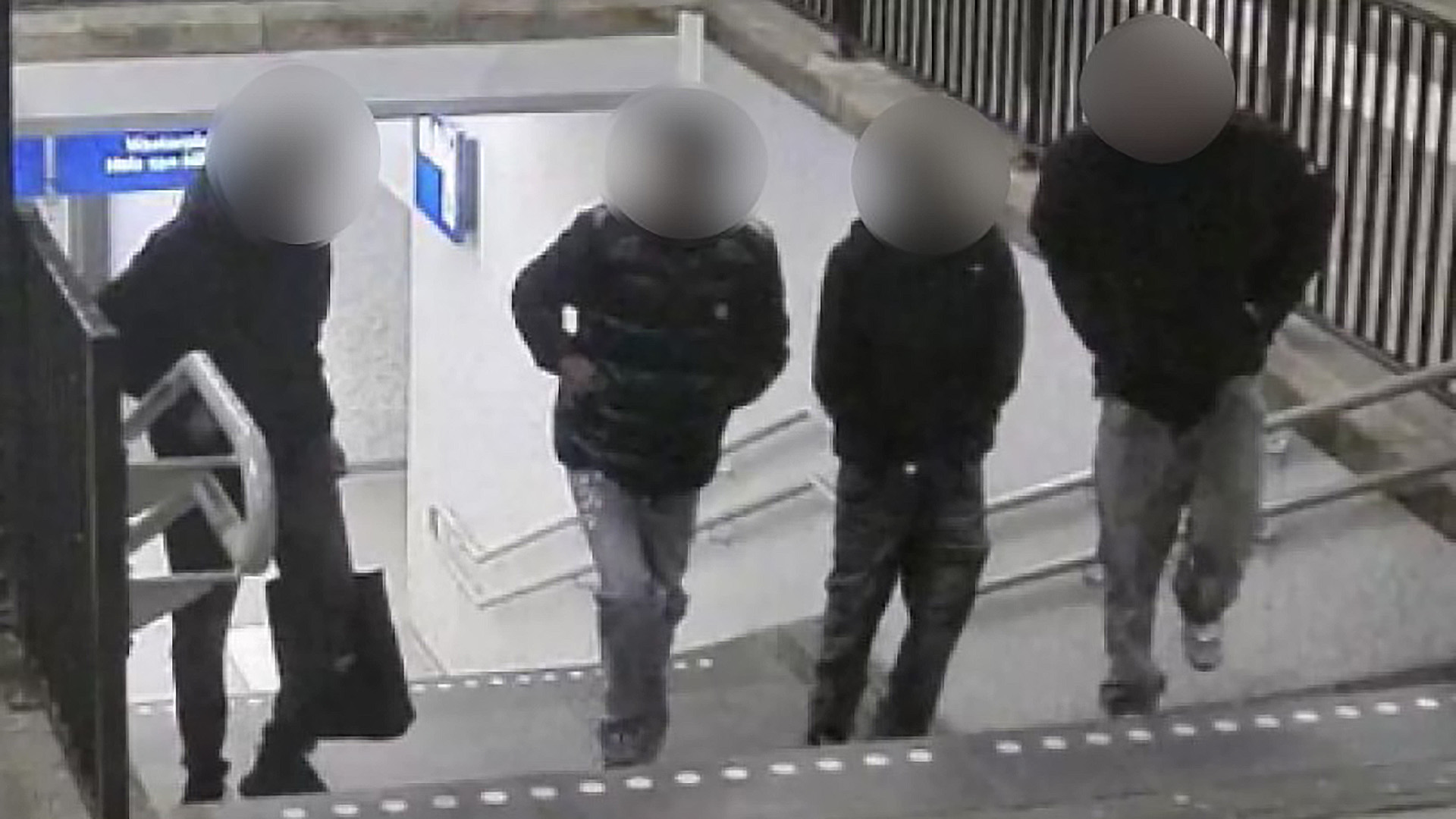 Vier silhouetten op een trap bij een ondergrondse doorgang, met gezichten onherkenbaar gemaakt.