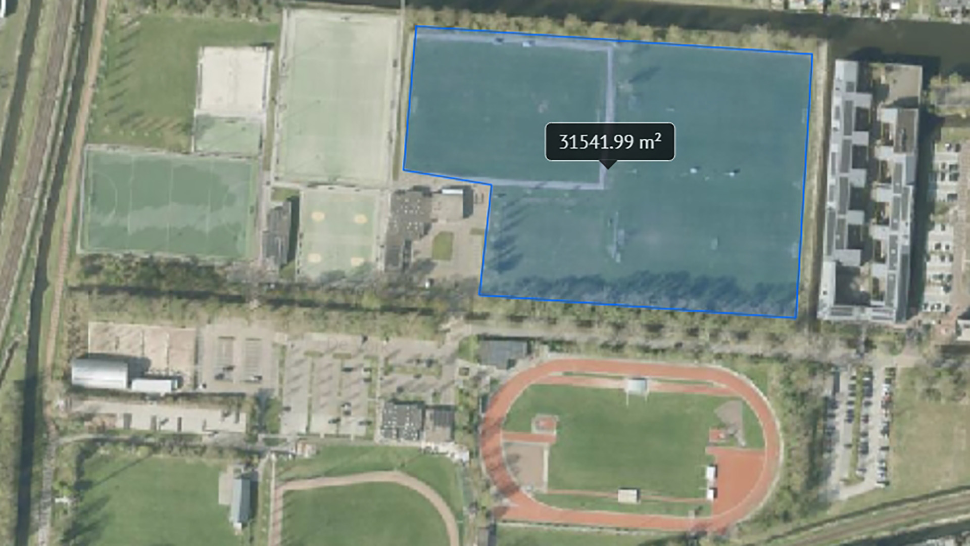 Luchtfoto van een sportcomplex met velden en een gemarkeerd gebied van 31.541,99 m².