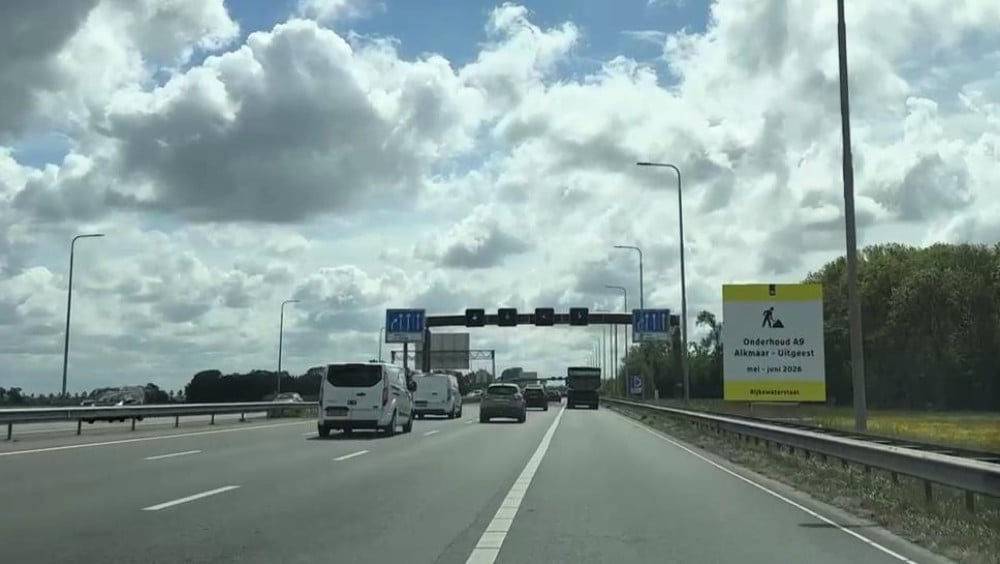 Verkeer op een snelweg onder een bewolkte hemel, met een bord dat onderhoud aan de A9 vermeldt van mei tot juni 2024.