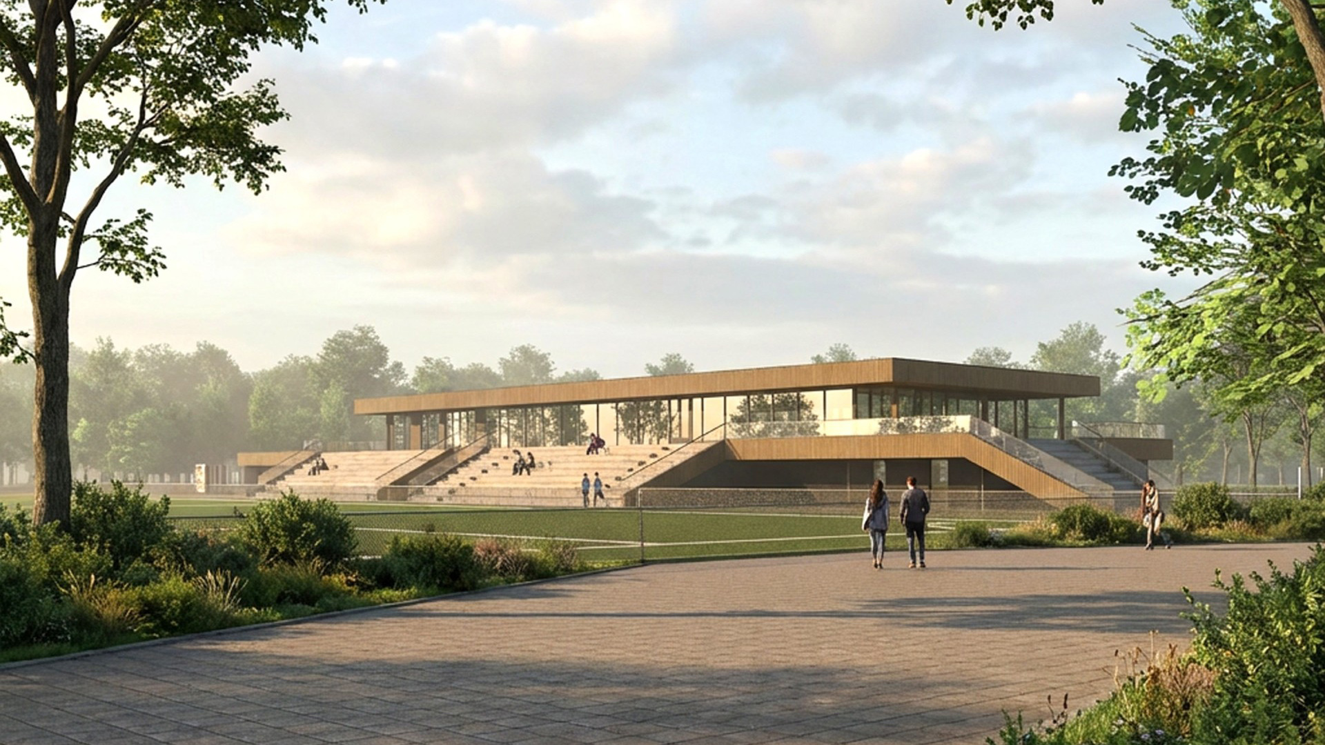 Modern sportcomplex met glazen gevels en brede trappen, omgeven door grasvelden en bomen, met mensen die wandelen en zitten.