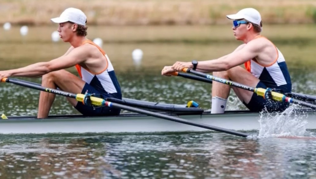 Twee roeiers in een tweepersoonsboot peddelen synchroon over het water tijdens een wedstrijd
