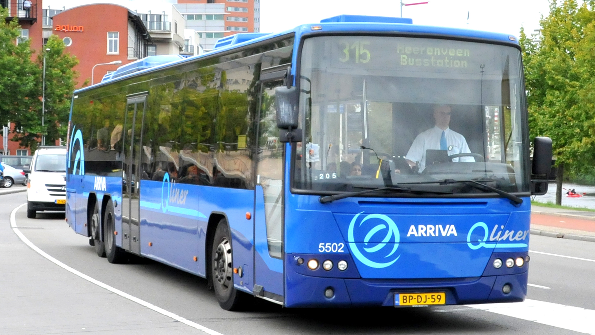 Blauwe Arriva Qliner-bus op lijn 315 naar Heerenveen Busstation rijdt over een stadsweg