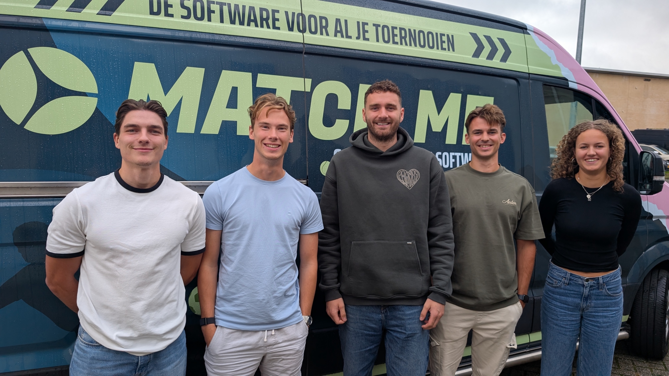 Vijf jonge volwassenen poseren voor een bus met MatchMe-logo en de tekst De software voor al je toernooien