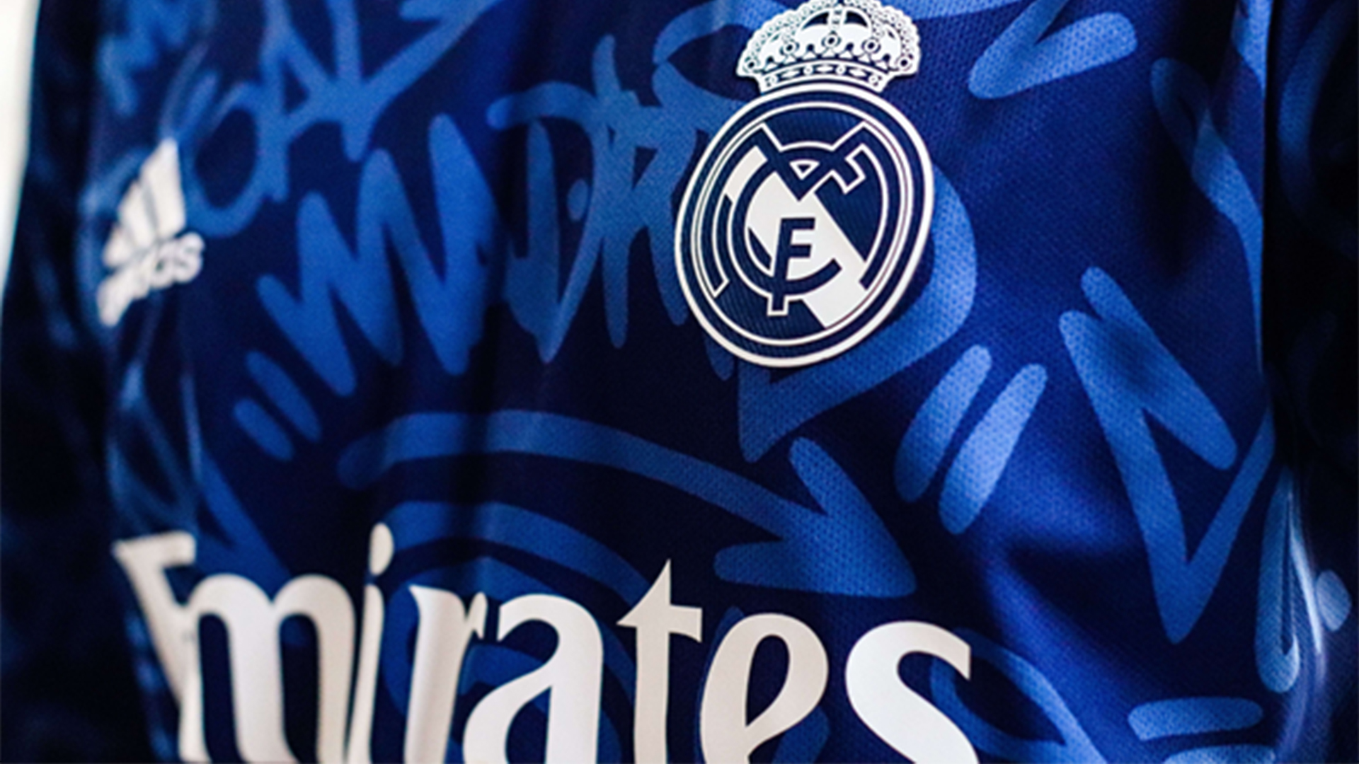 Close-up van een blauw Real Madrid-shirt met clubembleem en gedeeltelijk zichtbare sponsor Emirates