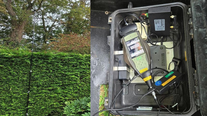 Meetopstelling in tuin met hoge antennemast; rechts een open koffer met meetapparaat en bekabeling
