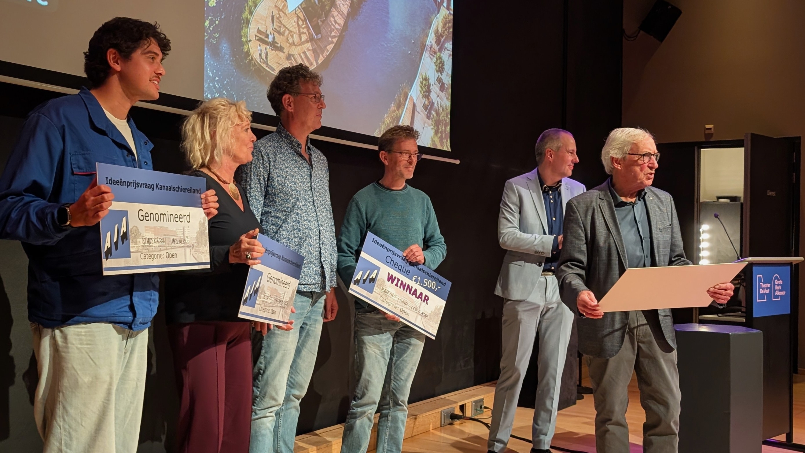 Groep mensen op podium met grote cheques “Ideeënprijsvraag Kanaalschiereiland”, met winnaar en genomineerden