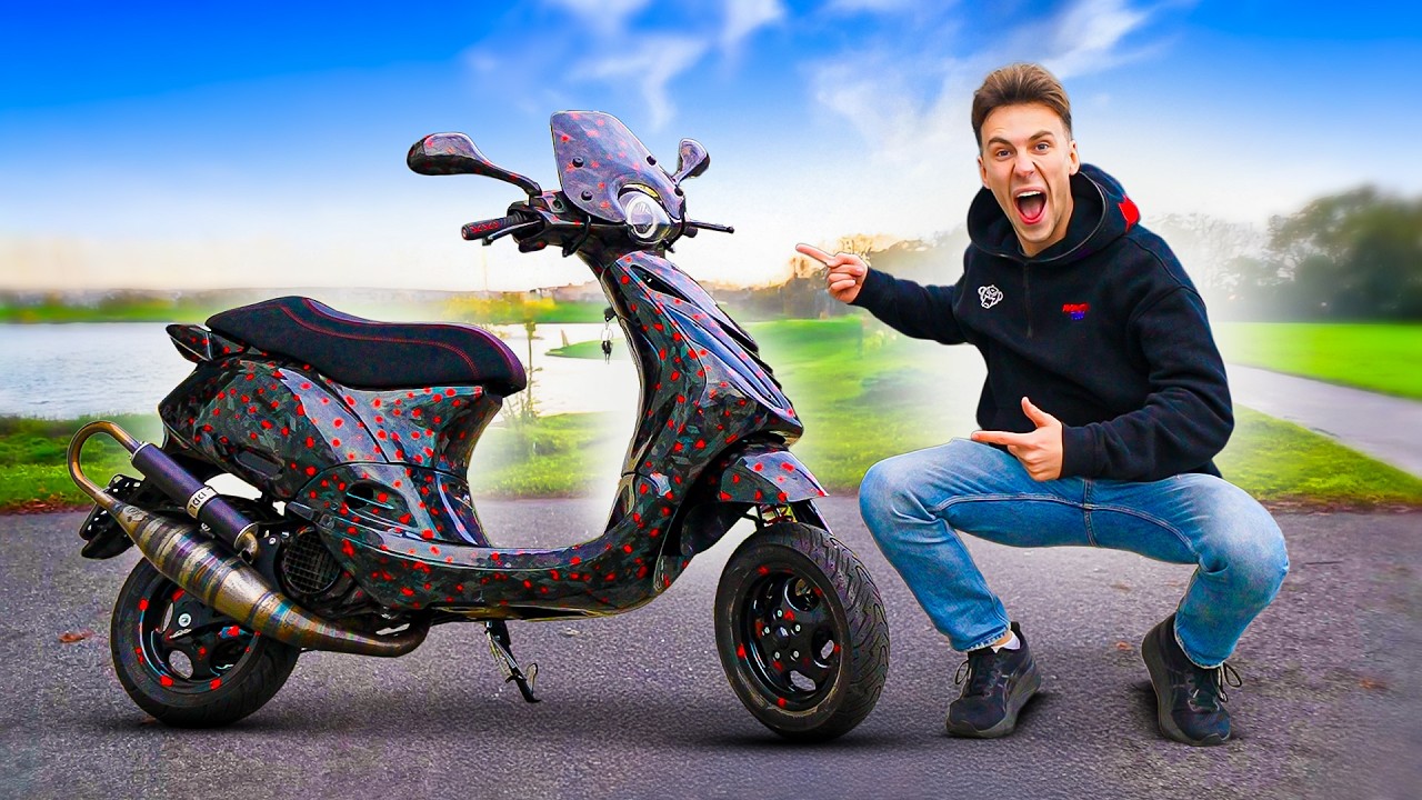 Jonge man hurkt en wijst enthousiast naar een zwart-rood gespikkelde scooter op een weg langs water en groen