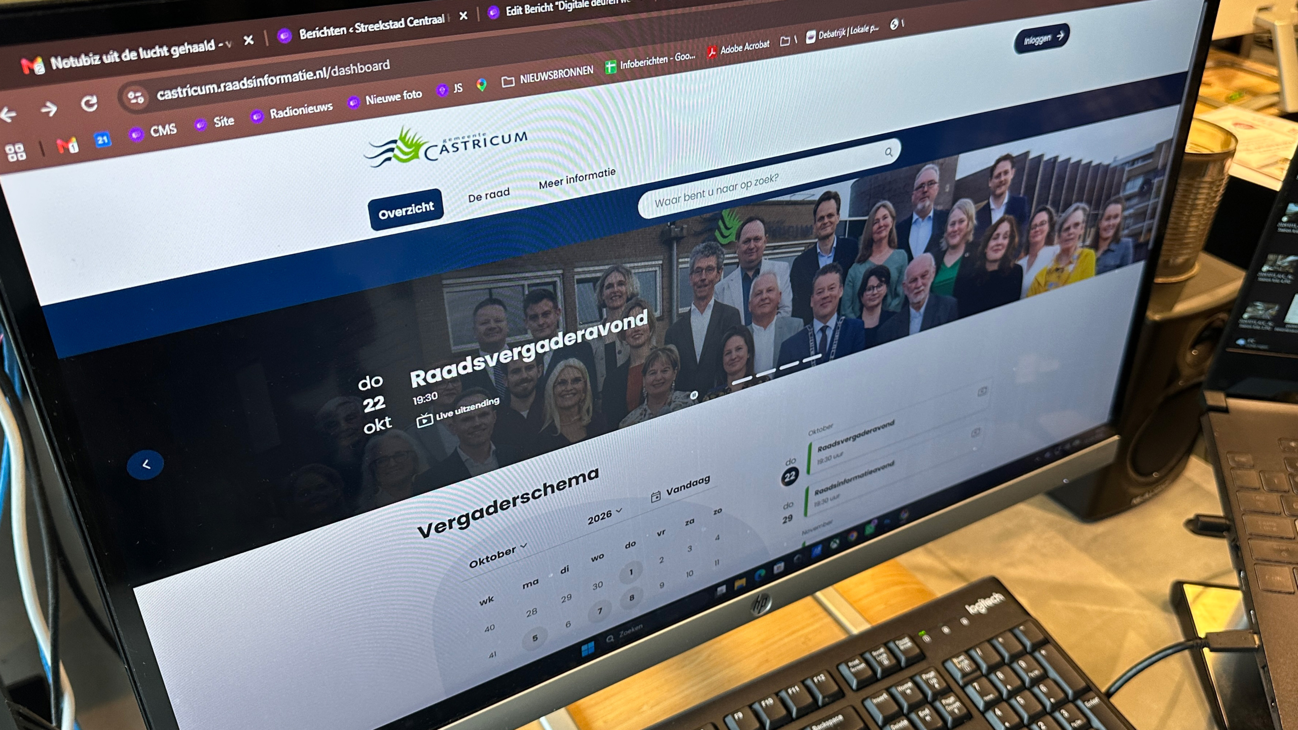 Computerscherm met de website van Gemeente Castricum en aankondiging “Raadsvergaderavond” met vergaderschema