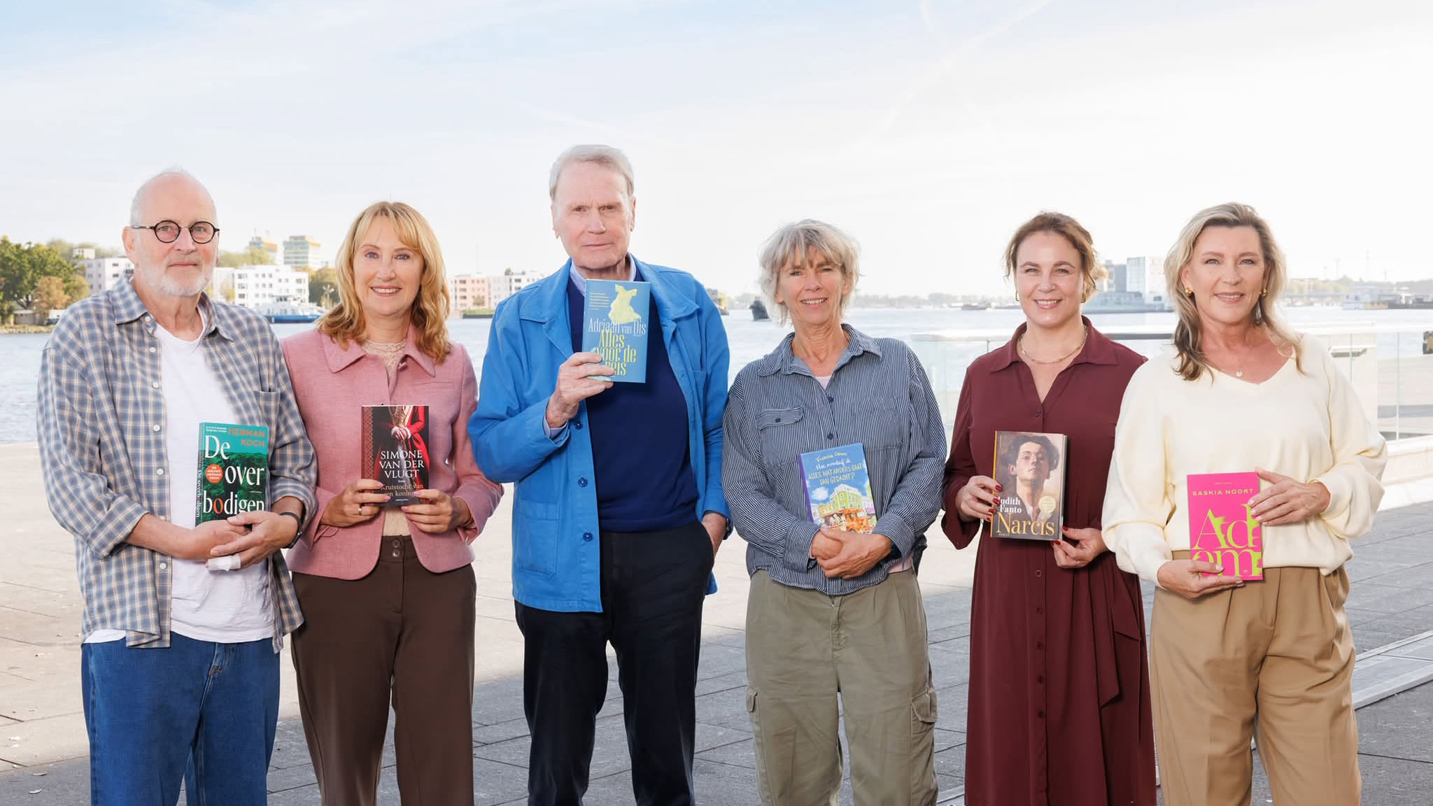 Zes personen poseren aan het water en houden boeken vast; op de covers staan o.a. De overbodigen, Narcis en Adem