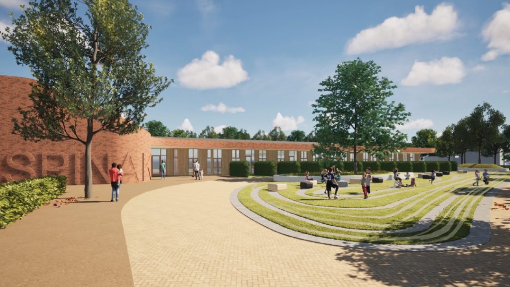 Schoolplein met laag bakstenen gebouw, bomen en groen amfitheater waar kinderen spelen en zitten